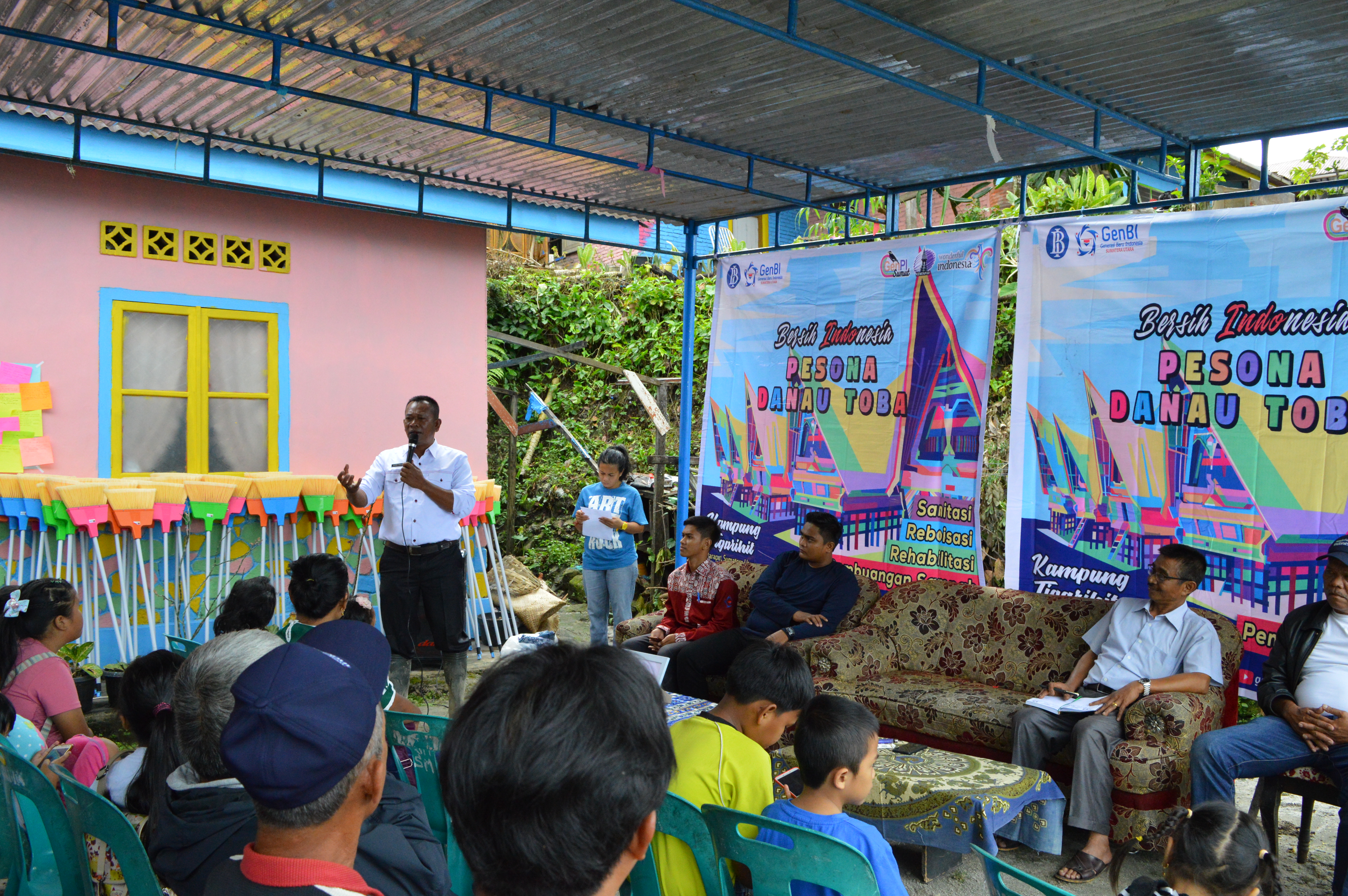 Penyerahan alat-alat bersih rumah tangga dari GenBI Sumut kepada Sekretaris Camat Huta Tigarihit sebagai tanda resmi dalam acara GenBI Bersih Indonesia 2018 di Parapat, Sumatera Utara. (19/12) (Sumber foto: Panitia Acara)